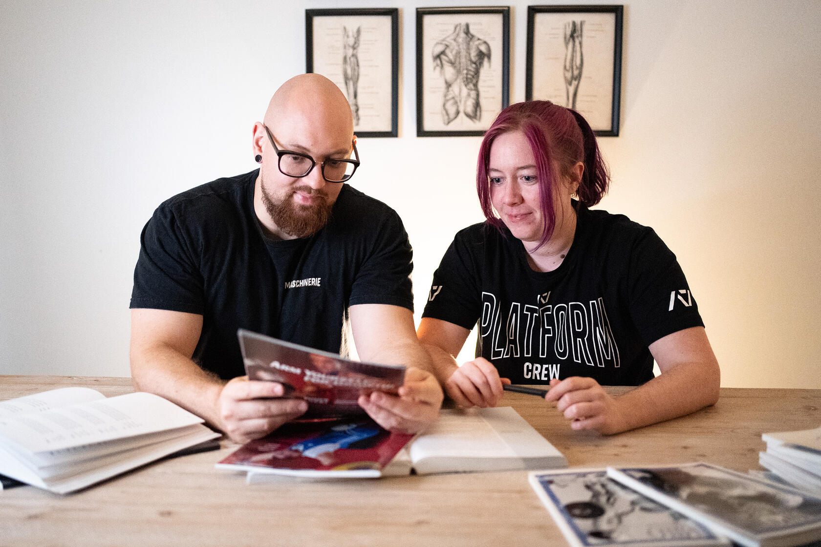 © Julia Ehrsam | juix.design Auf dem Bild ist eine beladenen Langhantel zu sehen. Es sind pro Seite vier rote Eleiko Gewichtsscheiben an je 25kg mit einem eisernen Verschluss festgemacht. Die Langhantel steht auf dem Teppichboden an einem Wettkampf. Im Hintergrund sind Menschen.